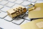 Kreditkarten liegen auf einer Computertastatur, gesichert durch ein Zahlenschloss. Symbol für Datensicherheit im Online-Banking und E-Commerce. #Datenschutz #Sicherheit #Onlinebanking